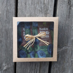 The Gift box - chocolate bilberries showcases three packs of chocolate-covered bilberries through its transparent window. Decorated with a rustic straw ribbon.